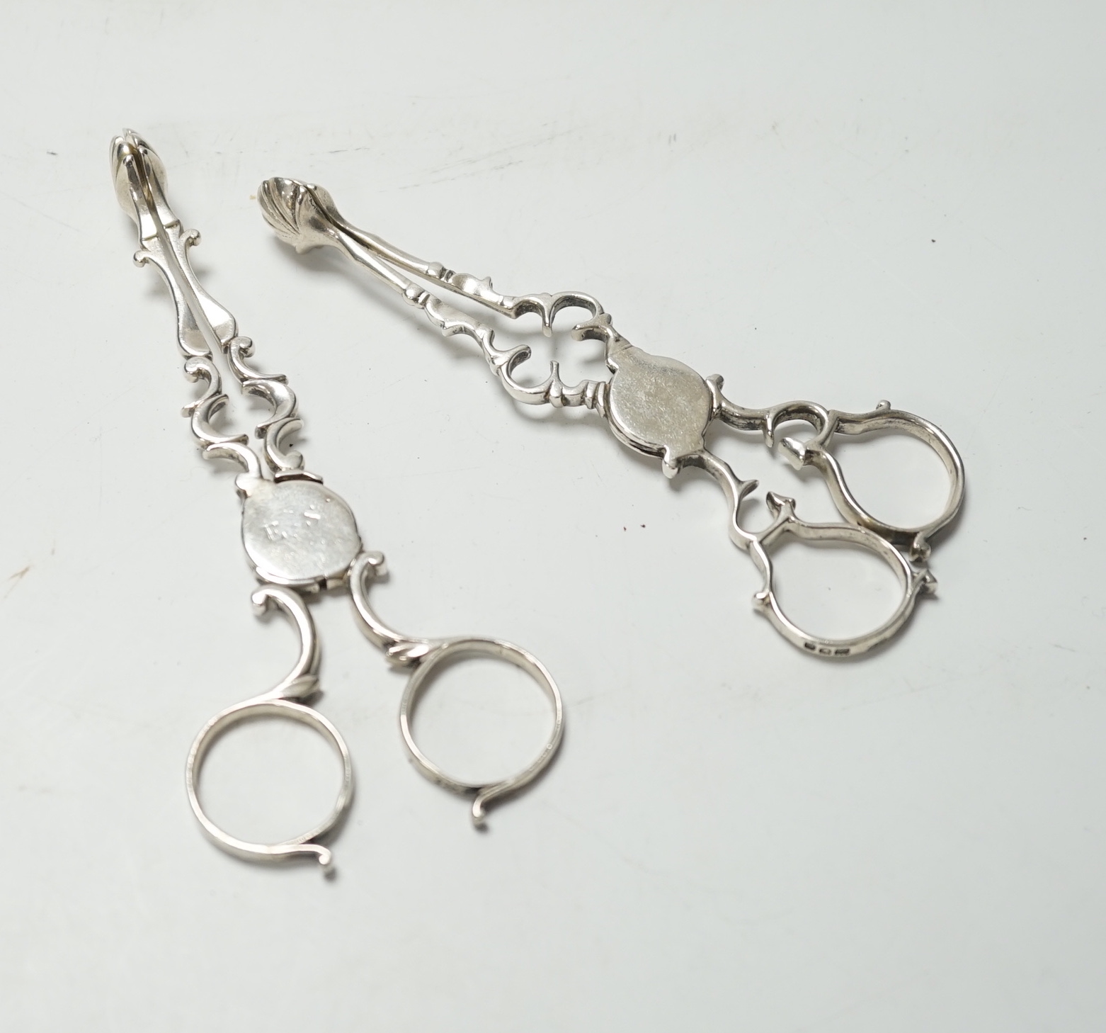 A pair of mid 18th century silver sugar nips, 12.3 cm and a pair of George V silver sugar nips.